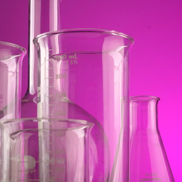 Scientific beakers against pink background